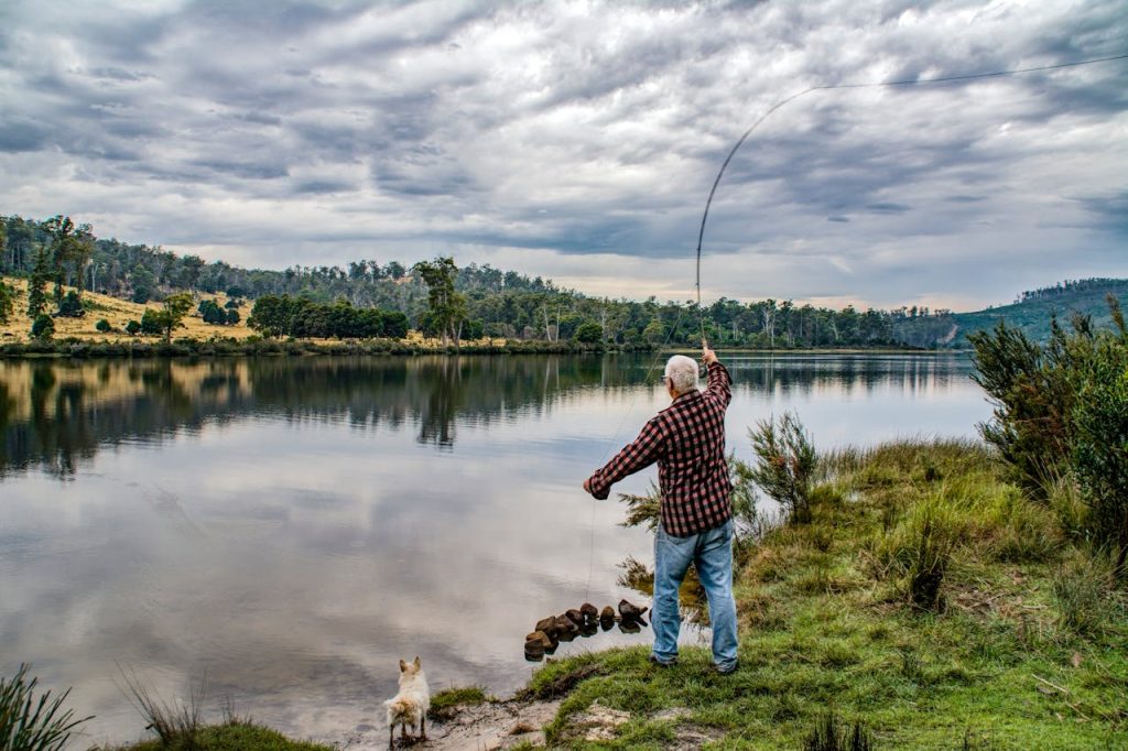 Guy along river casting